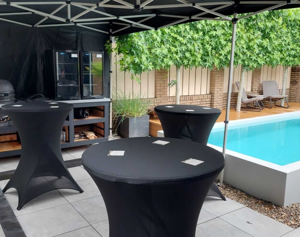 Luxe tuinfeest met partytent, zwarte statafels en zwembad